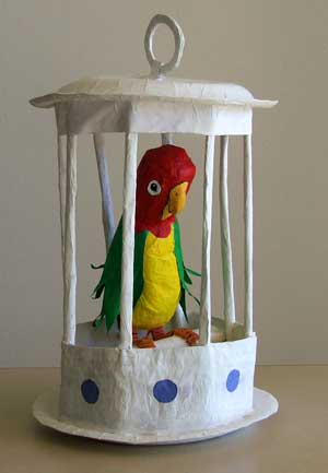 Paper parrot in a paper cage